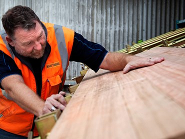 Tradesman Lining Up Wood in Warehouse 