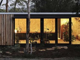 Full height sliding glass doors connect simple modular home to the outdoors