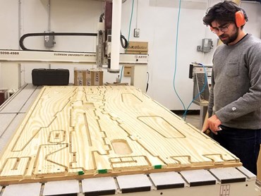 Architecture student Paul Mosher examines sim[PLY] pieces cut by a Computer Numeric Control device. Image: supplied
