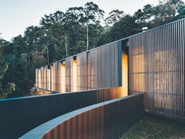 Glass home wrapped in sliding timber screens offers views and sun protection 
